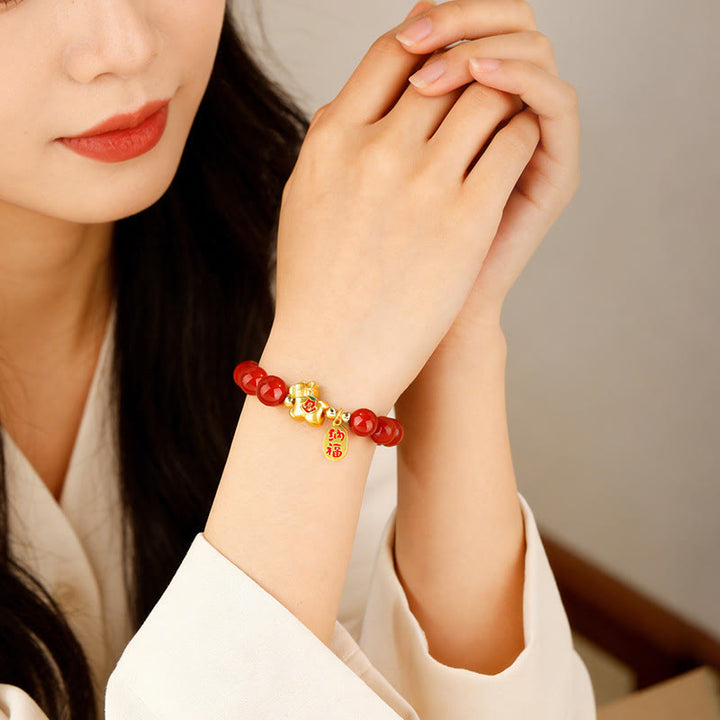 Armband Roter Achat – Erfolg & Balance am Handgelenk getragen mit goldenem Anhänger