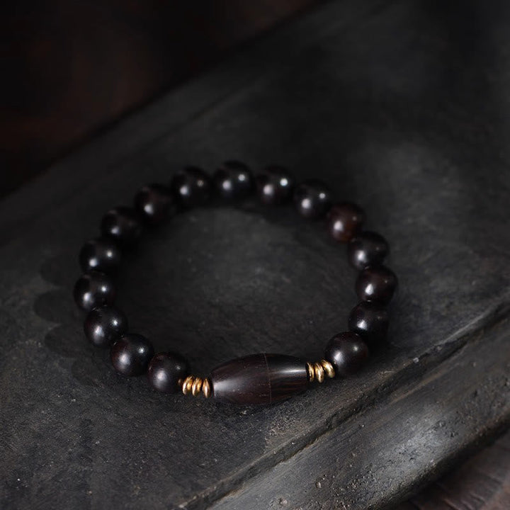 Armband Ebenholz – Schutz & Segen mit goldenen Akzenten auf Steinplatte