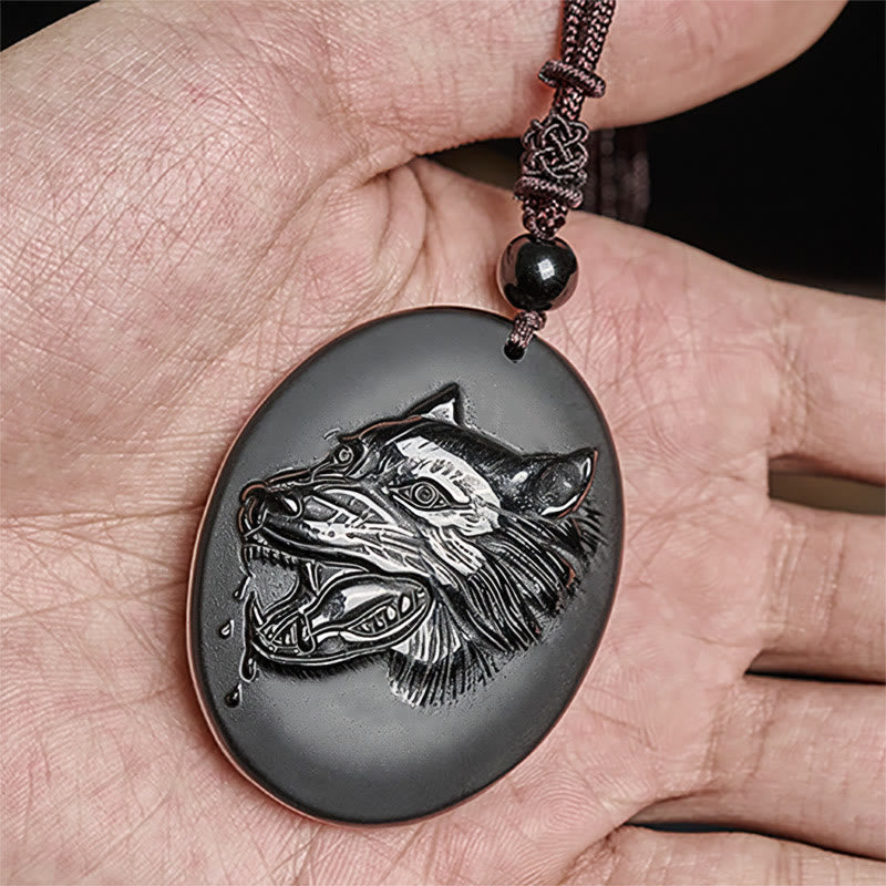 Schwarzer Obsidian Wolfanhänger an Kette in der Hand Stärke