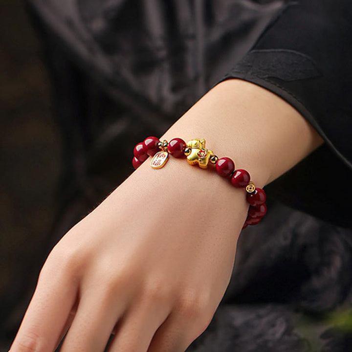 Armband Zinnober Pferd – Segen rote Perlen goldener Anhänger Handgelenk getragen