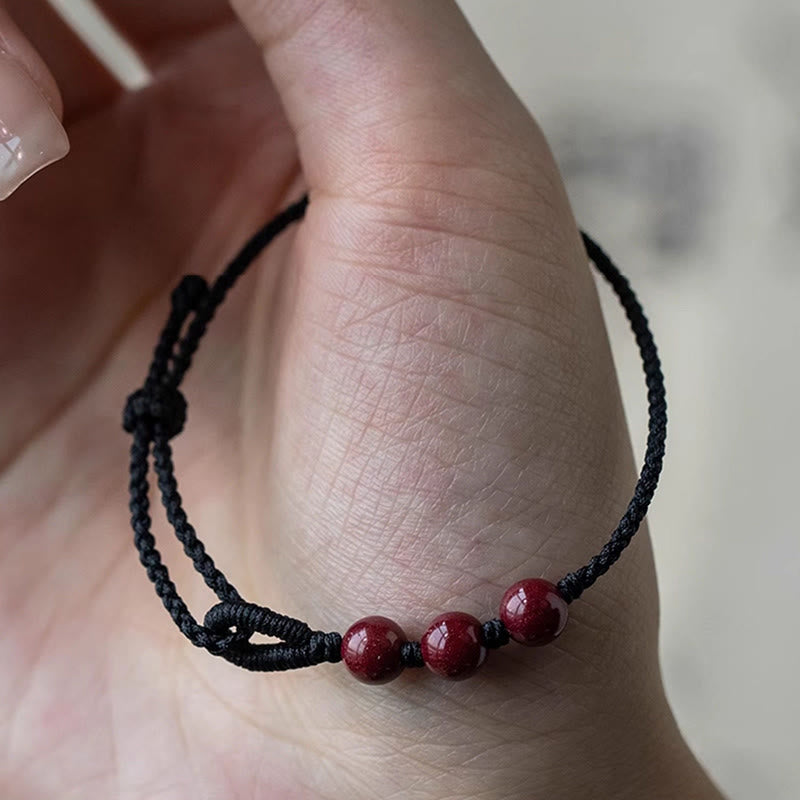 Armband Zinnober – Segen & Ruhe rote Perlen schwarzes Band Handgelenk getragen