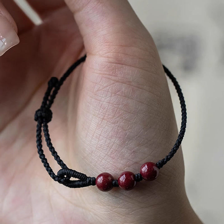 Armband Zinnober – Segen & Ruhe rote Perlen schwarzes Band Handgelenk getragen