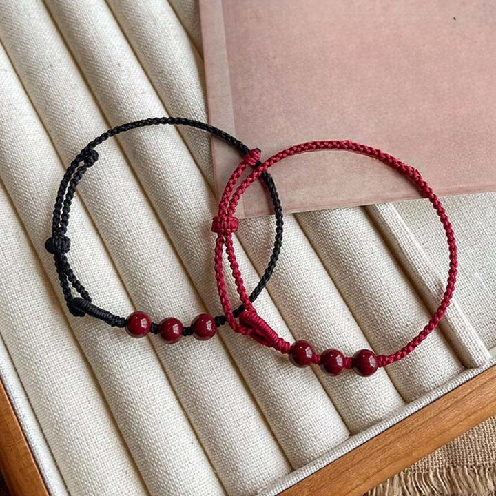 Armband Zinnober Segen Ruhe geflochten rote schwarze Schnur Perlen Handgelenk