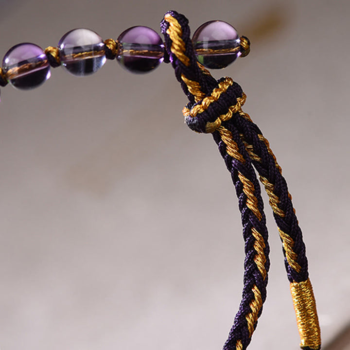 Armband Amethyst Zinnober Balance Glück geflochten Kordel violett goldene Perlen Detail