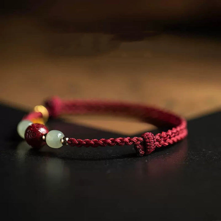 Armband Zinnober Jade Om Mani Padme Hum Wohlstand rotes geflochtenes Band
