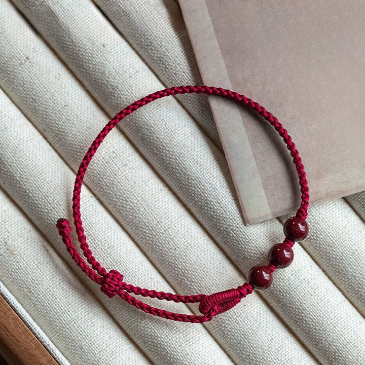 Armband Zinnober – Segen & Ruhe rote geflochtene Schnur mit drei Perlen