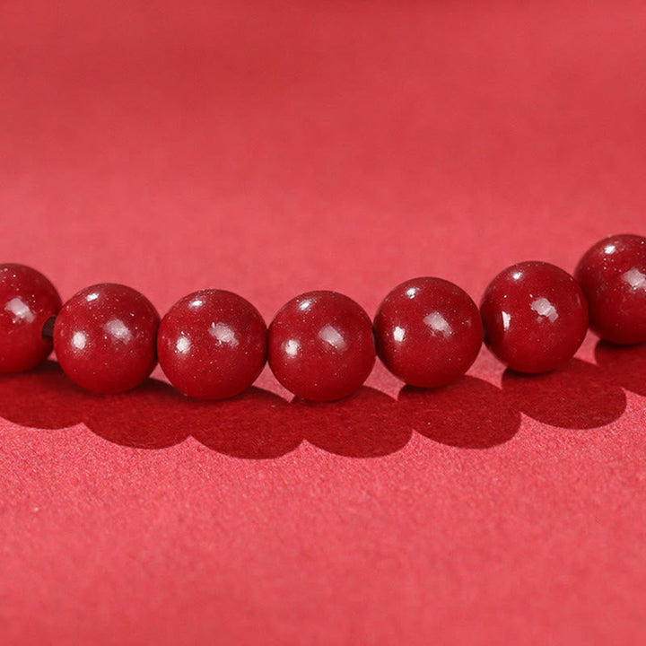Armband Zinnober Jade rote Perlen Nahaufnahme Schutz Glück Handgelenk Schmuck
