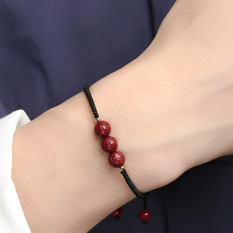 Armband Zinnober Om Mani Padme Hum rote Perlen schwarze Kordel