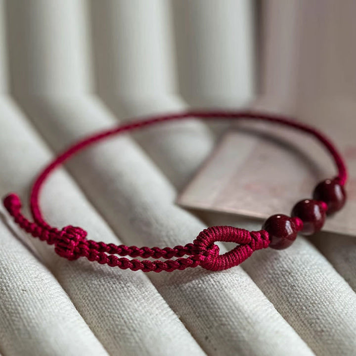 Armband Zinnober – Segen & Ruhe rote Kordel Perlen Handgelenk