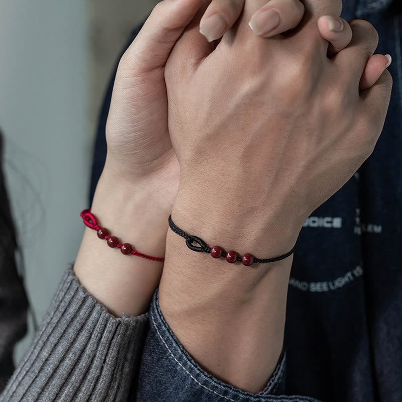 Armband Zinnober – Segen & Ruhe Paar getragen Handgelenk rote Perlen geflochten